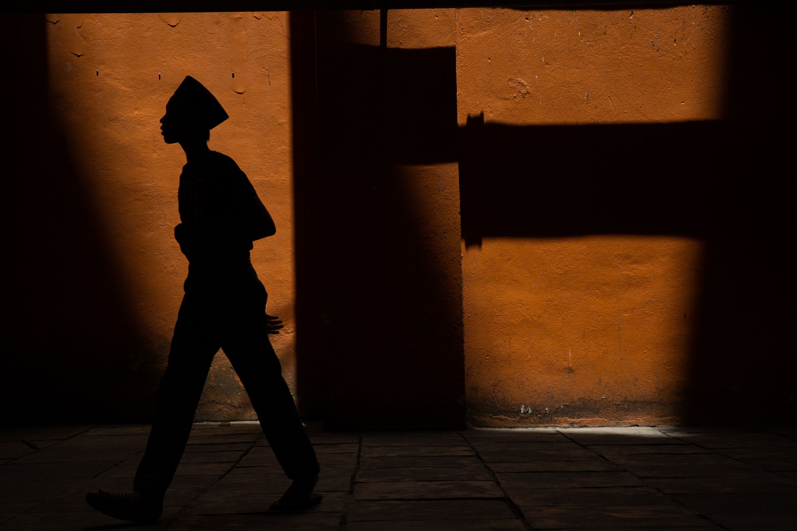 The shadow of a young Rohingya man walking to the mosque for Friday prayer in the Bagan Dalam district of Penang.